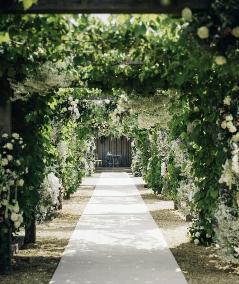 Záhradný chodník a Pergola s popínavými rastlinami a popínavými bielymi ružami.