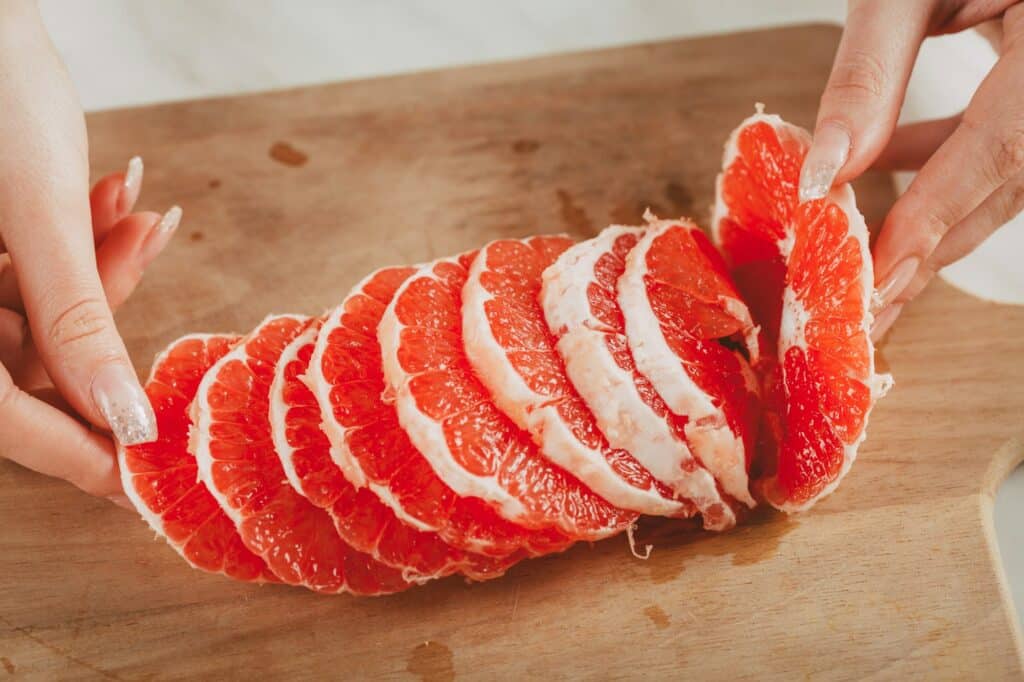 grapefruit - položený na drevenom prkénku pripravený na konzumáciu.